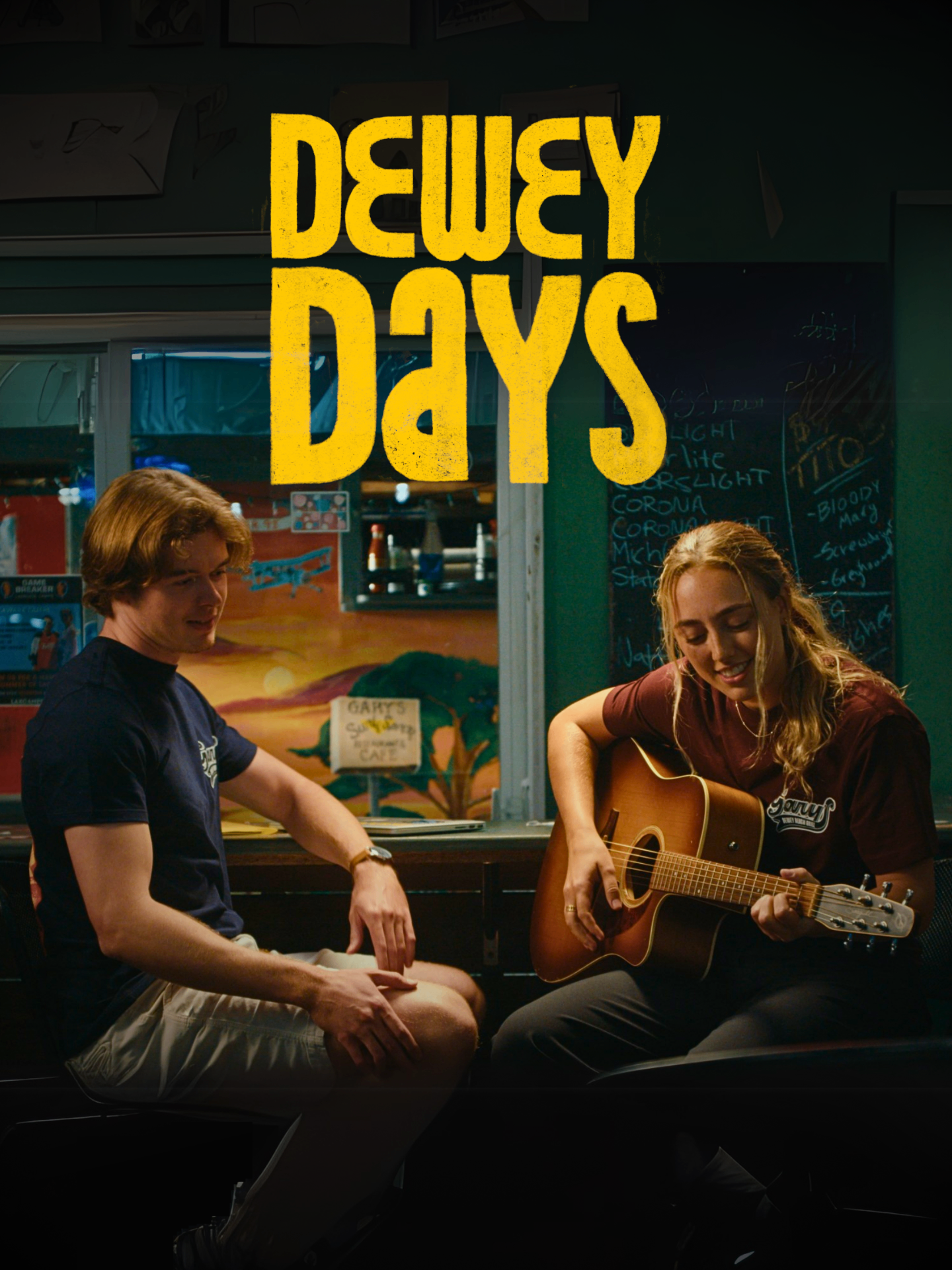 Dewey Days — official poster. Two friends inside a beach-town diner, one playing acoustic guitar.